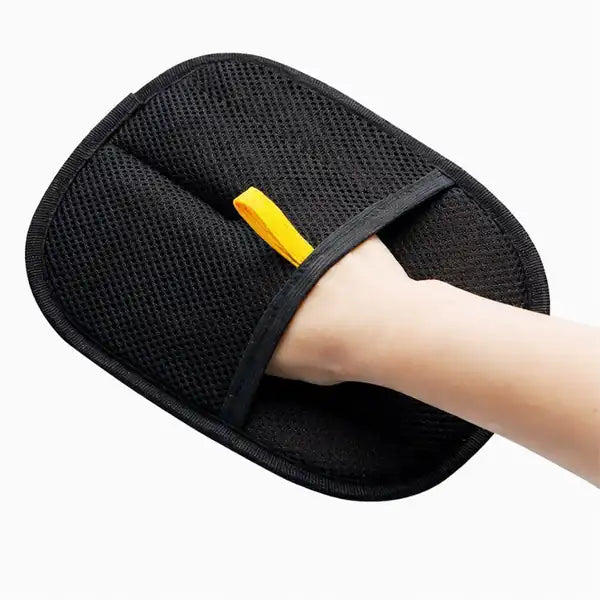 The Furvana Grooming Glove worn on a hand, mesh side up